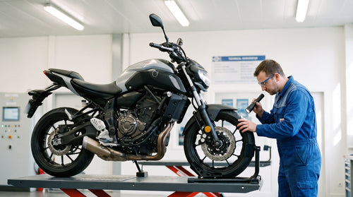 Contrôle technique moto : un contrôleur inspecte une moto sur le pont élévateur